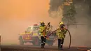 Petugas pemadam kebakaran berusaha menjinakkan kobaran api di dekat Wooroloo, timur laut Perth, Australia, Selasa (2/1/2021). Asap dan api dari kebakaran hutan membakar kota terbesar keempat di Australia ini, di tengah pemberlakuan lockdown virus corona COVID-19. (Evan Collis/DFES via AP)