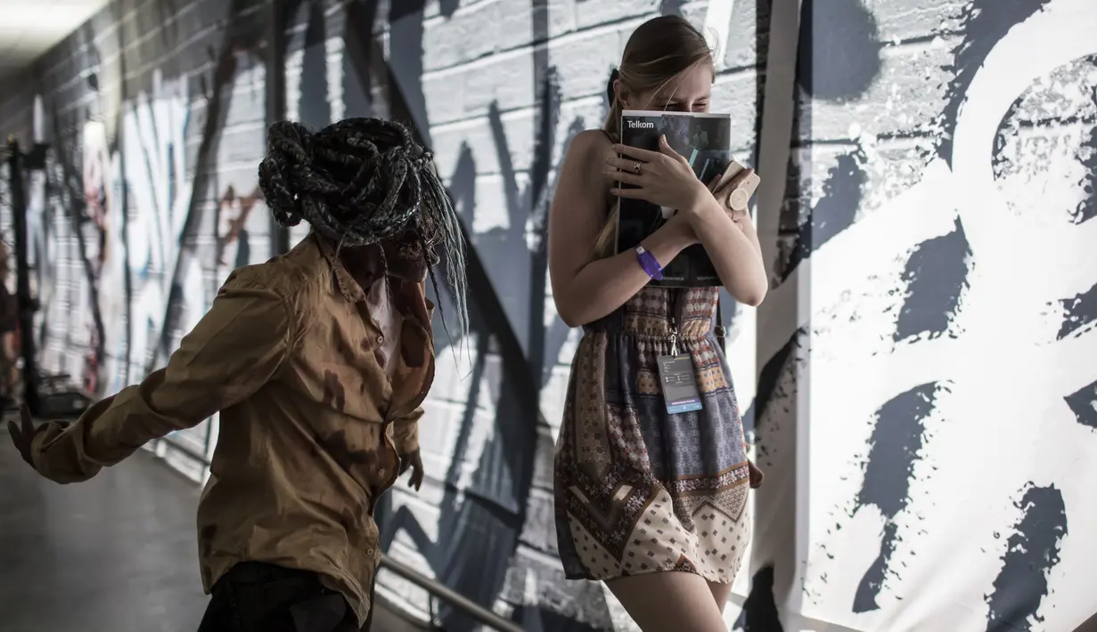 Cosplayer menggenakan kostum zombie menakuti pengunjung selama International Comic Con di Kyalami Race Course, Johannesburg, Afrika Selatan (14/9). Comic Con digelar pada tahun 1970. (AFP Photo/Marco Longari)