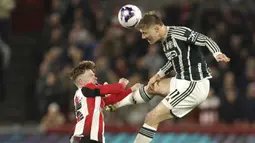 Striker Manchester United, Rasmus Hojlund (kanan) menyundul bola di bawah tekanan striker Brentford, Keane Lewis-Potter pada laga pekan ke-30 Premier League 2023/2024 di Gtech Community Stadium, London, Sabtu (30/3/2024). (AP Photo/Ian Walton)