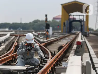 Pekerja melakukan pengecekan arus listrik pada jalur Light Rail Transit (LRT) Jakarta di Depo LRT Jakarta Pegangsaan Dua, Jakarta, Rabu (8/5/2024). (Liputan6.com/Angga Yuniar)