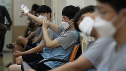 Calon tentara Korea Selatan yang mengenakan masker menunggu untuk menjalani pemeriksaan kesehatan di kantor Administrasi Tenaga Kerja Militer Seoul di Seoul, Senin (7/2/2022). (AP Photo/Ahn Young-joon)