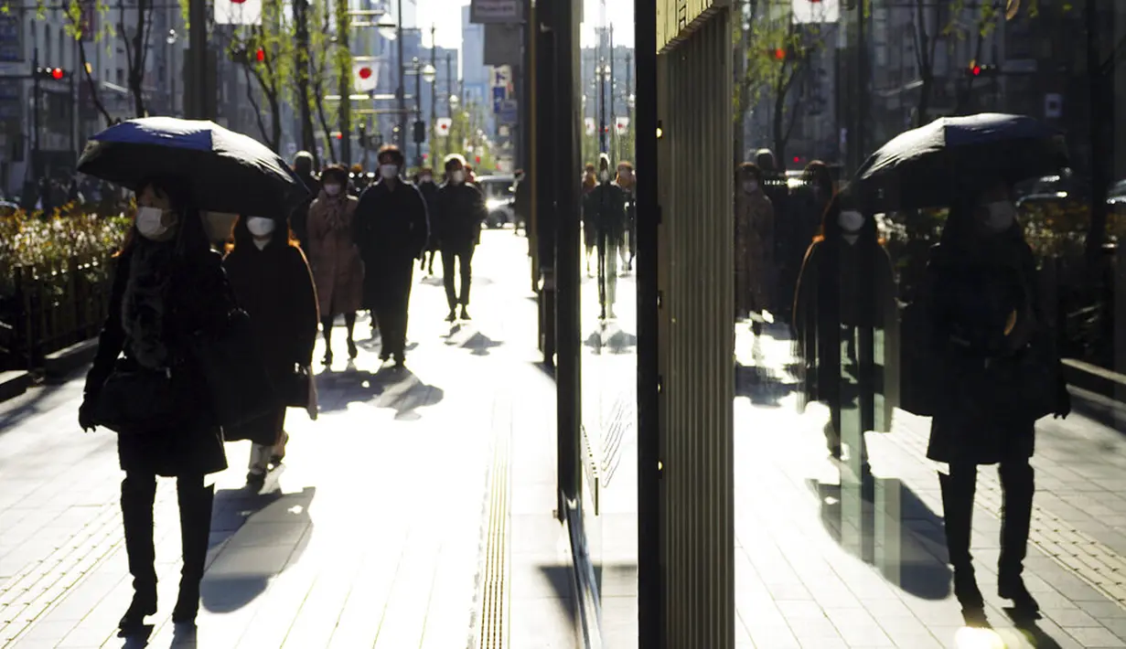 Orang-orang yang memakai masker untuk membantu mengekang penyebaran COVID-19 berjalan di sepanjang jalan perbelanjaan, Tokyo, Jepang, 29 Desember 2021. Kasus COVID-19 di Jepang meningkat lagi. (AP Photo/Eugene Hoshiko)