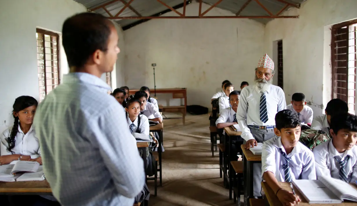 Durga Kami saat menjawab pertanyaan dari guru ketika jam pelajaran di ruang kelasnya di SMA Shree Kala Bhairab di Syangja, Nepal, 5 Juni 2016. Siapa sangka kakek berusia 68 tahun itu ternyata seorang siswa kelas X. (REUTERS/Navesh Chitrakar)