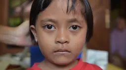 Ekspersi seorang anak saat menunggu giliran disuntik difteri di sebuah klinik desa di Jakarta (11/12). Wabah Difteri ini telah menewaskan puluhan orang. (AFP Photo/Adek Berry)