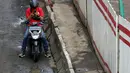 Pengendara beristirahat sebelum melintasi sebagian Jalan Rasuna Said, Kuningan yang rusak, Jakarta, Selasa (22/2/2022). Kerusakan jalan tersebut bisa membahayakan keselamatan pengendara dan menghambat arus lalu lintas. (Liputan6.com/Helmi Fithriansyah)