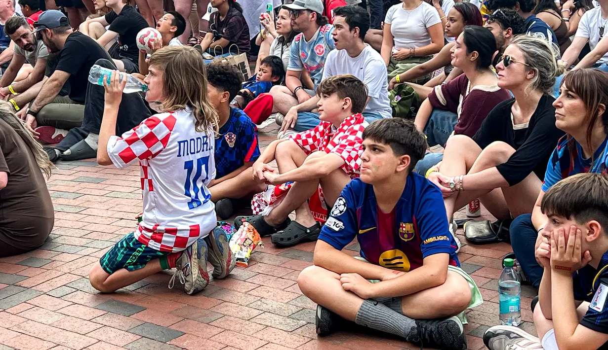Pengunjung dengan berbagai atribut klub dan tim nasional menyaksikan laga Inggris kontra Kroasia di FIFA Fan Festival Boston, AS, Rabu (17/6/2026). Area ini menjadi titik kumpul pencinta sepak bola selama Piala Dunia 2026. (KLY Sports/Hery Kurniawan/Adv/Powerade)