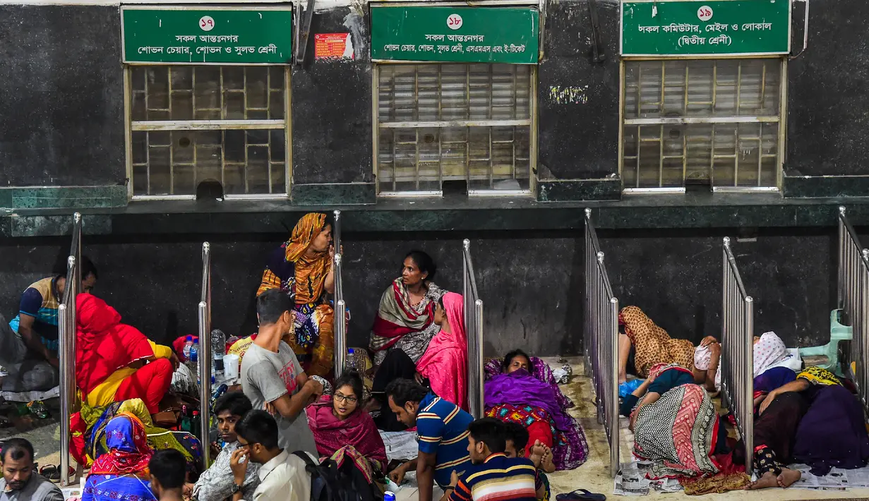 Sejumlah calon pembeli duduk dan tidur di depan loket untuk mendapatkan tiket mudik lebaran di Stasiun Kereta Kamalapur, Dhaka, Kamis (23/5/2019). Pemudik Bangladesh rela antre berjam-jam dan bahkan menunggu jauh hari sebelum pembukaan loket tiket. (MUNIR UZ ZAMAN/AFP)