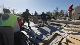 Para pekerja memindahkan kursi dari Pusat Komunitas Flatwood setelah badai tornado menghancurkan fasilitas tersebut dan menyebabkan beberapa orang tewas di Flatwood, Alabama (30/11/2022). (AP Photo/Butch Dill)