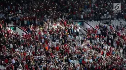 Penonton bergoyang menyalakan ponsel pintar jelang pembukaan Asian Games 2018 di Stadion Gelora Bung Karno, Jakarta, Sabtu (18/8). Dengan slogan "Energy of Asia", upacara pembukaan Asian Games mengusung budaya khas Indonesia. (Liputan6.com/ Fery Pradolo)