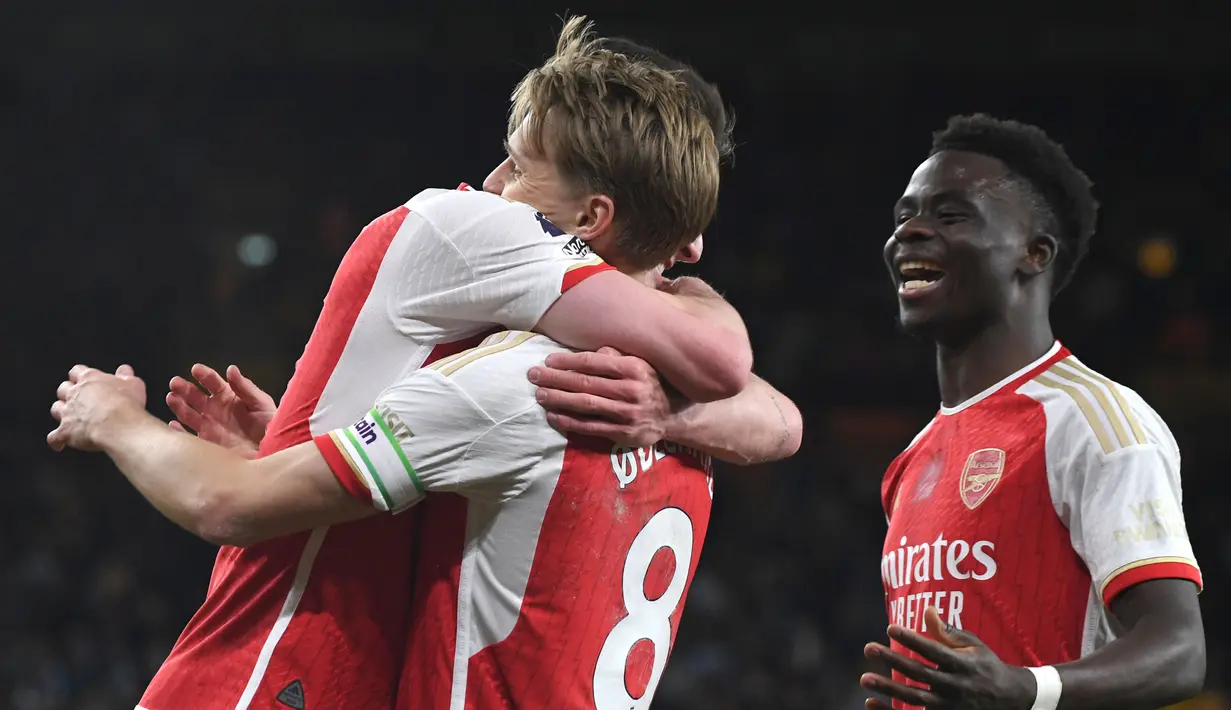 Pemain Arsenal Martin Odegaard (tengah) merayakan dengan rekan setimnya setelah mencetak gol kedua timnya selama pertandingan sepak bola Liga Premier Inggris melawan Wolverhampton Wanderers di Stadion Molineux, Inggris, Sabtu, 20 April 2024. (AP Photo/Rui Vieira)