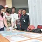 Keluarga korban melihat foto properti dari jenazah korban KM Zahro yang belum teridenfikasi di RS Polri, Jakarta, Selasa (3/1). Penempelan foto hasil postmortem bertujuan untuk membantu pengenalan oleh pihak keluarga. (Liputan6.com/Yoppy Renato)