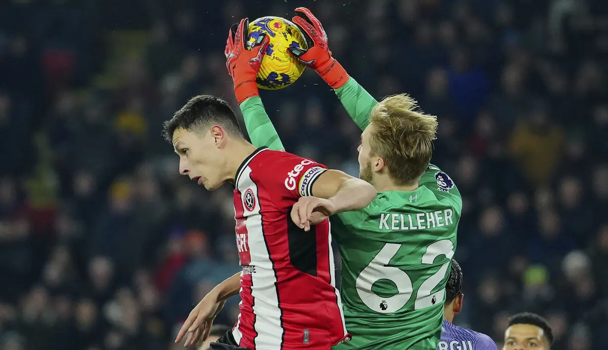 Kiper Liverpool, Caoimhin Kelleher (kanan) berhasil menangkap bola dari ancaman bek Sheffield United, Anel Ahmedhodzic pada laga pekan ke-15 Liga Inggris 2023/2024 di Bramall Lane, Sheffield, Kamis (7/12/2023) dini hari WIB. (AP Photo/Jon Super)