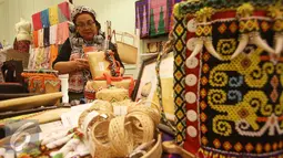 Peserta merapikan produk saat pemeran bertajuk Karya Kreatif Indonesia di Jakarta, Jumat (26/8). Pameran tersebut diselenggarakan dalam rangka mempromosikan produk Usaha Mikro Kecil Menengah (UMKM) dari seluruh Indonesia. (Liputan6.com/Immanuel Antonius)