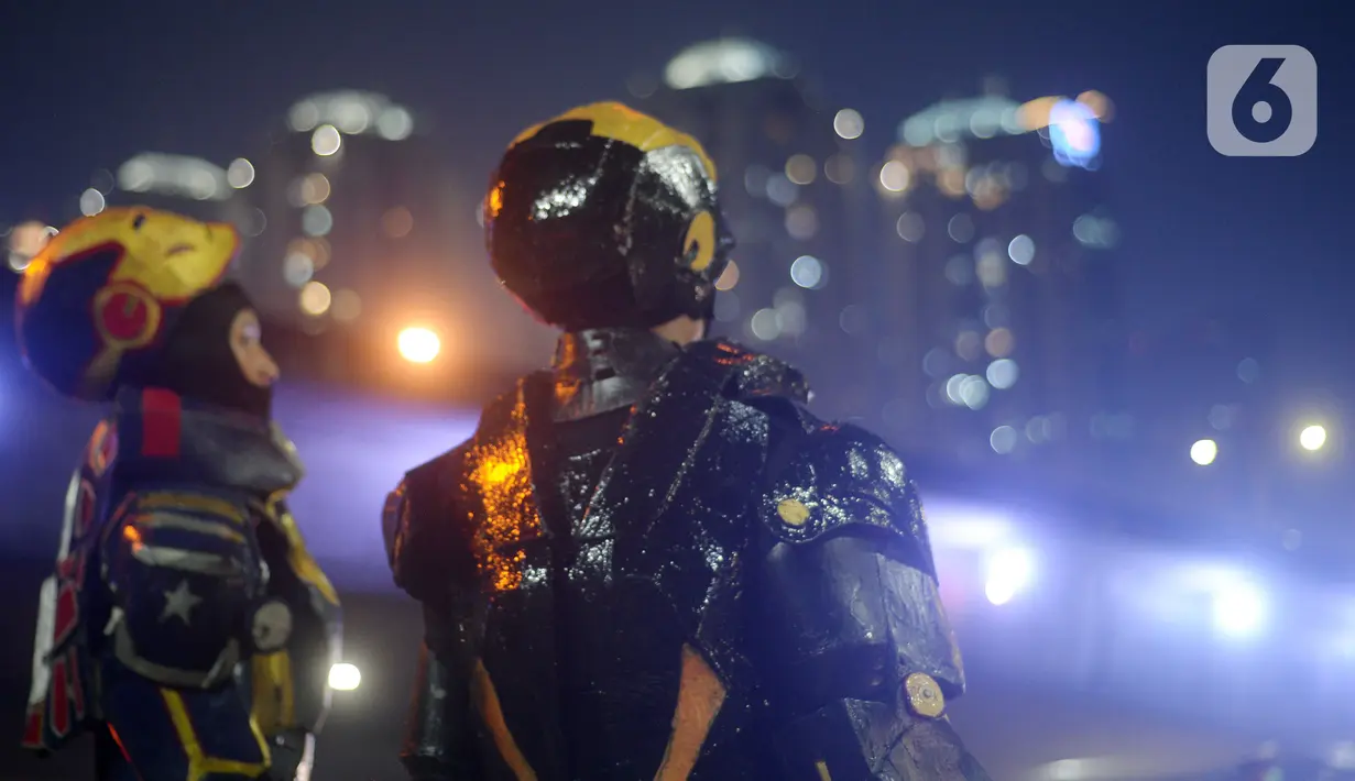 Dua robot saat menghibur pengendara di kawasan Tomang, Jakarta, Selasa (14/9/2021). Abi (20) dan Nujum (48) mengenakan kostum robot Iron Man untuk mengais rejeki dan menghibur para pengendara dari kemacetan lalu lintas yang dilakukan sejak pandemi COVID-19. (merdeka.com/Imam Buhori)