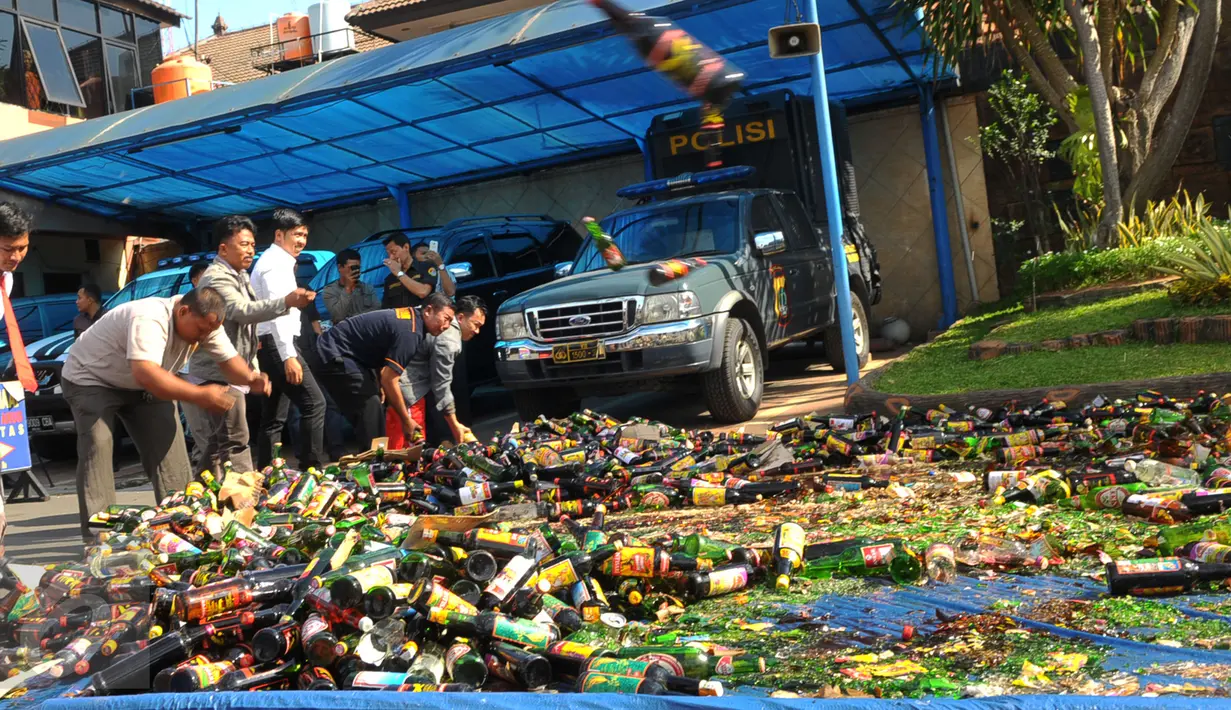 Sejumlah petugas saat melakukan pemusnahan miras di di Polres Kota Tangerang Banten, Rabu, (23/12). Polresta Tangerang memusnahkan miras sebanyak 11.155 botol dan 264 Ciu yang berkemas botol mineral. (Liputan6.com/Faisal R Syam)