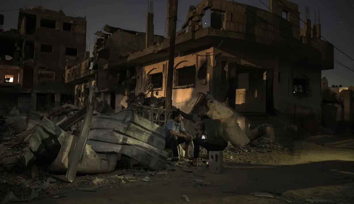 Warga Palestina bermalam di samping rumah mereka yang hancur baru-baru ini di kota Beit Hanoun, Jalur Gaza utara, Rabu (26/5/2021). Serangan udara Israel selama 11 hari ke Jalur Gaza mengakibatkan ratusan jiwa tewas, ribuan rumah dan bangunan hancur. (AP Photo/Khalil Hamra)