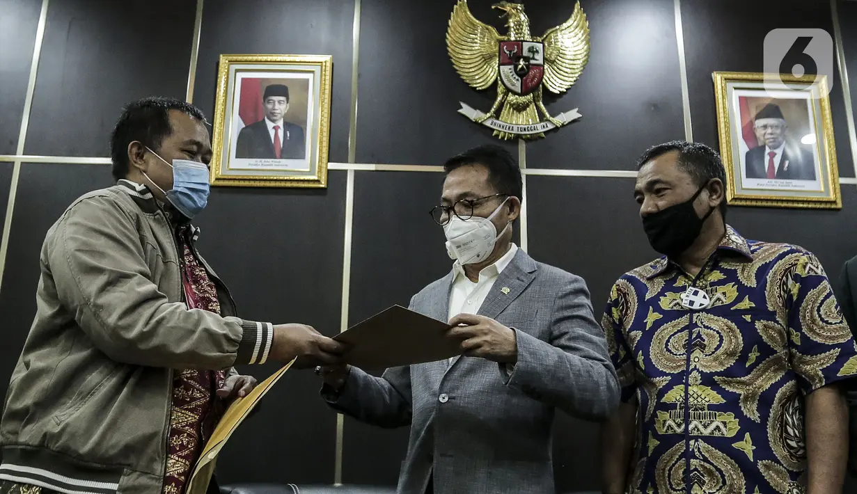 Koordinator MAKI Boyamin Saiman (kiri) menyerahkan salinan surat jalan Djoko Tjandra kepada Ketua Komisi III DPR Herman Herry di Kompleks Parlemen, Jakarta, Selasa (14/7/2020). Komisi III DPR berencana membentuk panitia khusus karena kasus itu melibatkan banyak instansi. (Liputan6.com/Johan Tallo)