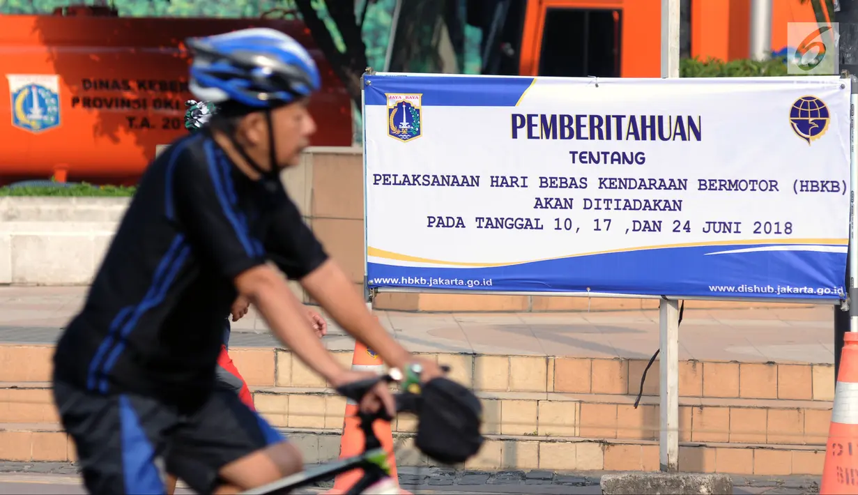 Warga melintasi spanduk pemberitahuan peniadaan pelaksanaan Hari Bebas Kendaraan Bermotor (HBKB) di sekitar Bundaran Hotel Indonesia, Jakarta, Minggu (3/6). Pelaksanaan HBKB akan ditiadakan pada 10, 17, dan 24 Juni 2018. (Liputan6.com/Helmi Fithriansyah)