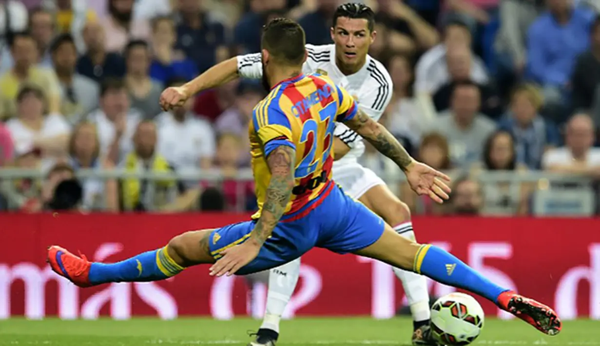 Nicolas Otamendi menghadang bintang Real Madrid, Cristiano Ronaldo pada laga La Liga di Stadion Santiago Bernabeu, Spanyol, Sabtu (9/5/2015). Otamendi musim lalu sukses membawa Valencia berada di peringkat empat klasemen. (AFP Photo/Gerard Julien)