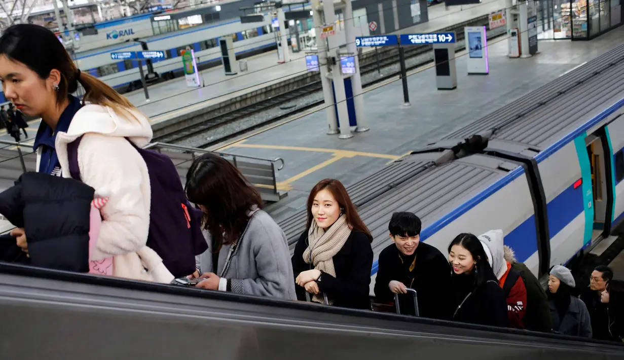 Sejumlah warga menggunakan eskalator di sebuah stasiun kereta api di Seoul, Korea Selatan, (19/2). (AFP Photo/David Gannon)