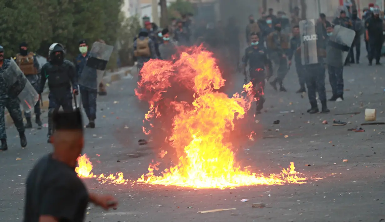 Pasukan keamanan berusaha membubarkan para demonstran saat protes antipemerintah di dekat Alun-Alun Tahrir, Baghdad, Irak, Senin (27/7/2020). Perdana Menteri Irak mengatakan telah memerintahkan penyelidikan atas pembunuhan dua demonstran antipemerintah. (AP Photo/Hadi Mizban)