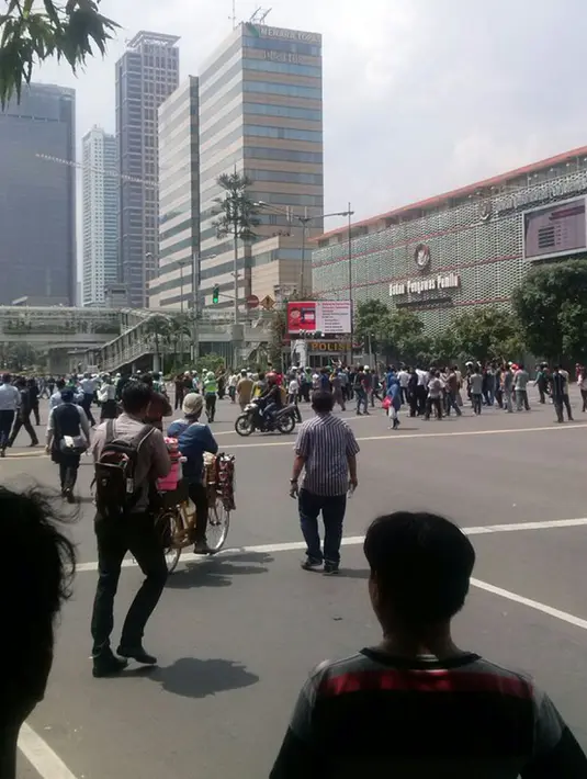 Sejumlah orang berkerumun di sekitar lokasi ledakan yang terjadi di pos polisi di depan Mal Sarinah, Jakarta, Kamis (14/1). Sampai berita ini diturunkan belum ada pihak aparat kepolisian yang dikonfirmasi mengenai informasi ini. (twitter.com/ ferrykoto)