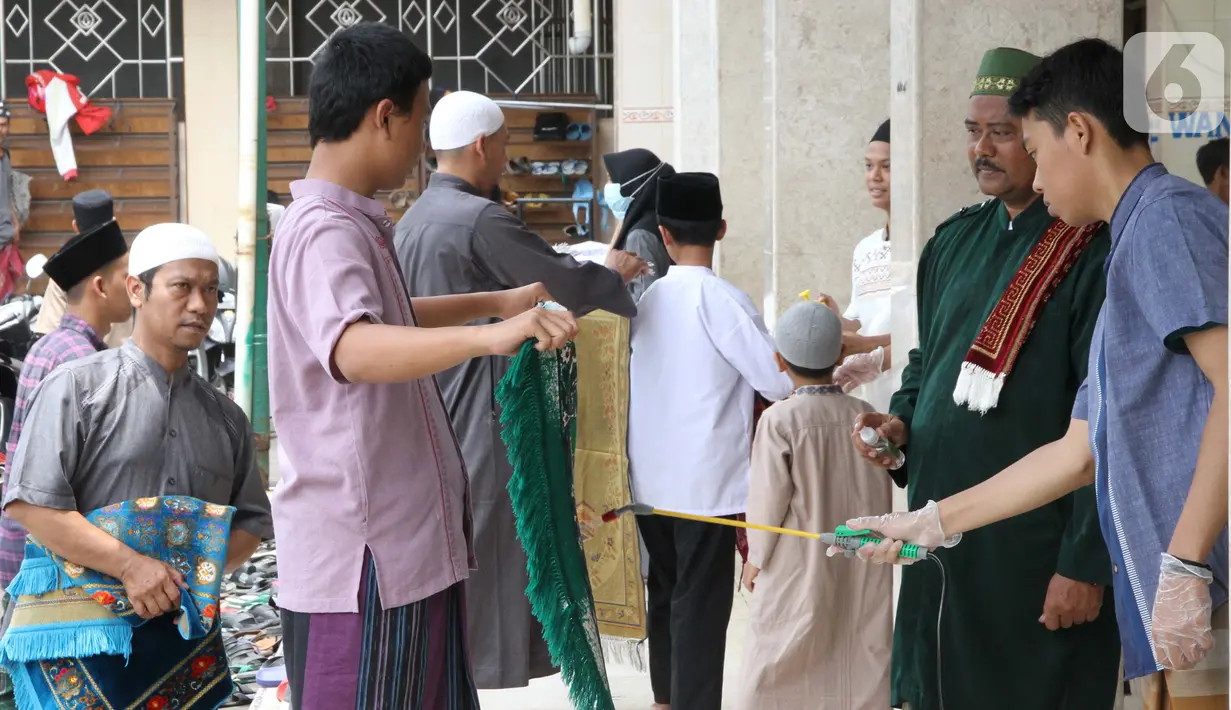 Petugas menyemprotkan cairan disinfektan ke sajadah jemaah sebelum Salat Jumat di Masjid El-Syifa, Jakarta, Jumat (20/3/2020). Sejumlah masjid di Jakarta masih menggelar salat Jumat meski ada imbauan dari MUI terkait merebaknya virus corona atau COVID-19. (Liputan6.com/Fery Pradolo)