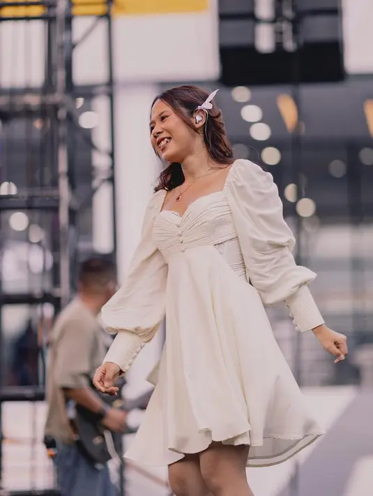 Nadin Amizah dengan dress vintage berwarna putih. Penampilannya di atas panggung terlihat manis dengan dress pendek berlengan panjang ini. [Foto: Instagram/cakecaine]
