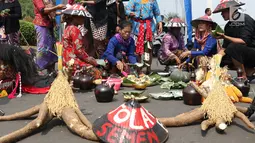 Sejumlah petani Kendeng membagi makanan saat aksi di depan Istana Negara, Jakarta, Kamis (2/8). Dalam aksinya, petani Kendeng melakukan tradisi Brokohan atau makan bersama nasi aneka urap yang sebelumnya didoakan. (Liputan6.com/Helmi Fithriansyah)