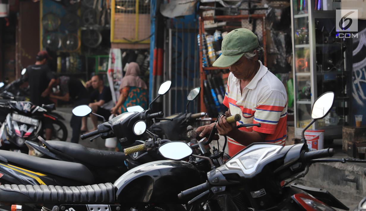 Mekanik mengecek motor pelanggan di sebuah bengkel di Otista, Jakarta, Minggu (10/6). Calon pemudik motor mulai memenuhi bengkel guna menyervis atau mengganti suku cadang kendaraan sebelum digunakan untuk mudik Lebaran. (Liputan6.com/Angga Yuniar)