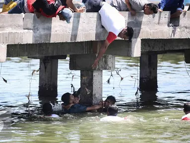 Warga berusaha menolong seorang anak kecil yang terjatuh ke laut di dermaga Muara Angke, Jakarta, Kamis (24/3). Akibat kelalaian ibunya seorang anak tercebur ke laut dan langsung di selamatkan warga dan prajurit TNI AL. (Liputan6.com/Faizal Fanani)