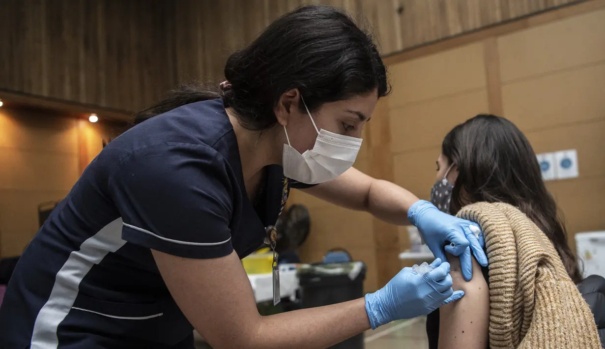 Petugas kesehatan menyuntikan vaksin COVID-19 Pfizer BioNTech kepada seorang anak di pusat vaksinasi di Santiago, Chile, Rabu (23/6/2021). Chile mulai memvaksinasi anak-anak dari usia 12 tahun, sebagai salah upaya untuk memutus rantai penyebaran infeksi virus Corona. (MARTIN BERNETTI/AFP)