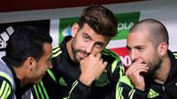 Gerard Pique berbincang santai dengan dua rekannya asal Barcelona di bangku cadangan Spanyol (CESAR MANSO / AFP)