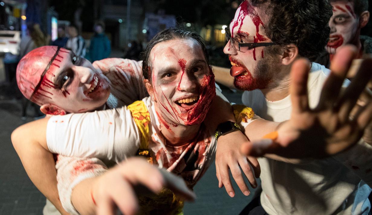 Sejumlah peserta mengenakan kostum menyerupai zombie berpose saat difoto dalam perayaan hari Purim di Tel Aviv (11/3). Perayaan ini sebagai bentuk peringatan orang Yahudi bebas dari rencana jahat Haman. (AFP/Jack Guez)