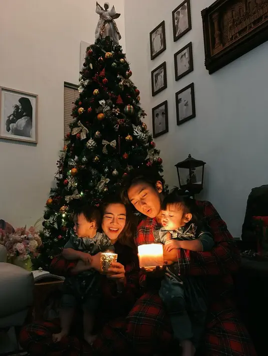 Keluarga Felicya Angelista dan Hito Caesar saat merayakan Natal. Lewat foto berlatar pohon Natal, Felicya dan Hito memilih memangku masing-masing anak mereka dengan suasana gelap dan memegang lilin. Tema outfit keluarga ini juga menarik karena Felicya dan Hito tampil dengan piyama merah kembar, sedangkan kedua anaknya juga dipakaikan piyama abu-abu kembar. [Foto: Instagram/felicyangelista_]