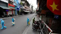 Petugas medis yang mengumpulkan sampel tes pada hari pertama pemberlakuan lockdown dari warga yang melintas di Kota Ho Chi Minh, Vietnam, Jumat (9/7/2021). Pemerintah Vietnam memberlakukan lockdown dua minggu di Kota Ho Chi Minh. (AFP/Huu Khoa)