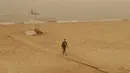 Seorang pria berjalan di pantai sambil mengenakan masker di Beirut , Lebanon, 8 September 2015. Badai pasir besar melanda Timur Tengah, menewaskan 2 orang dan ratusan orang dirawat di rumah sakit di Lebanon. (REUTERS/Mohamed Azakir)