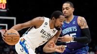 Pemain Nets Kevin Durant melewati adangan pemain Hornets PJ Washington pada lanjutan NBA (AFP)