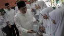 Inisiator gerakan Nusantara Mengaji Muhaimin Iskandar membagikan buku kepada anak-anak saat membuka Nusantara Bertauhid di Ciganjur, Jakarta, Kamis (14/3). Acara ini mengusung tema 'Khataman Alquran untuk Persatuan Indonesia'. (Liputan6.com/Faizal Fanani)