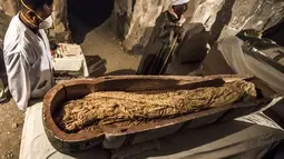 Arkeolog berdiri dekat mumi wanita bernama Thuya dalam sarkofagus di Luxor, Meisr, Sabtu (24/11). Sarkopafus itu adalah salah satu dari dua sarkofagus yang ditemukan awal bulan ini, dalam sebuah misi pencarian oleh peneliti Prancis. (Khaled DESOUKI/AFP)