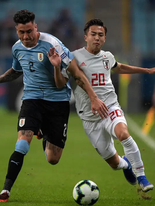 Striker Kashima Antlers, Hiroki Abe berusaha merebut bola dari pemain Uruguay Jose Maria Gimenez selama pertandingan Copa America di Stadion Gremio Arena di Porto Alegre, Brasil pada 20 Juni 2019. Abe merupakan pemain muda terbaik J-League pada 2018. (AFP Photo/Carl De Souza)