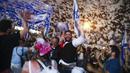 Warga Israel merayakan pelantikan pemerintahan baru di Tel Aviv, Israel, Minggu (13/6/2021). Parlemen Israel telah memberikan suara mendukung pemerintahan koalisi baru yang secara resmi mengakhiri 12 tahun pemerintahan bersejarah Perdana Menteri Benjamin Netanyahu. (AP Photo/Oded Balilty)
