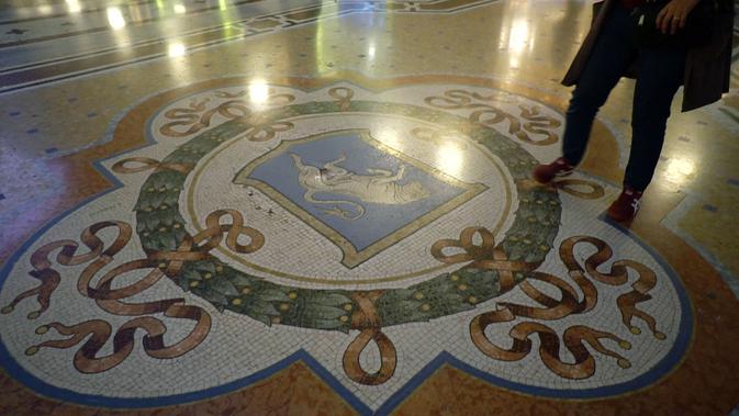 Pengunjung Galleria Vittorio Emanuele II tengah menginjak testis banteng yang menjadi lambang pasukan bersenjata Torino. (Liputan6.com/Marco Tampubolon)