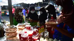 Sejumlah wanita mengenakan masker di pasar, sebagai bagian dari upaya untuk menghentikan penyebaran virus corona Covid-19, selama bulan suci Ramadhan di provinsi selatan Thailand, Narathiwat (17/4/2021). (AFP/Madaree Tohlala)