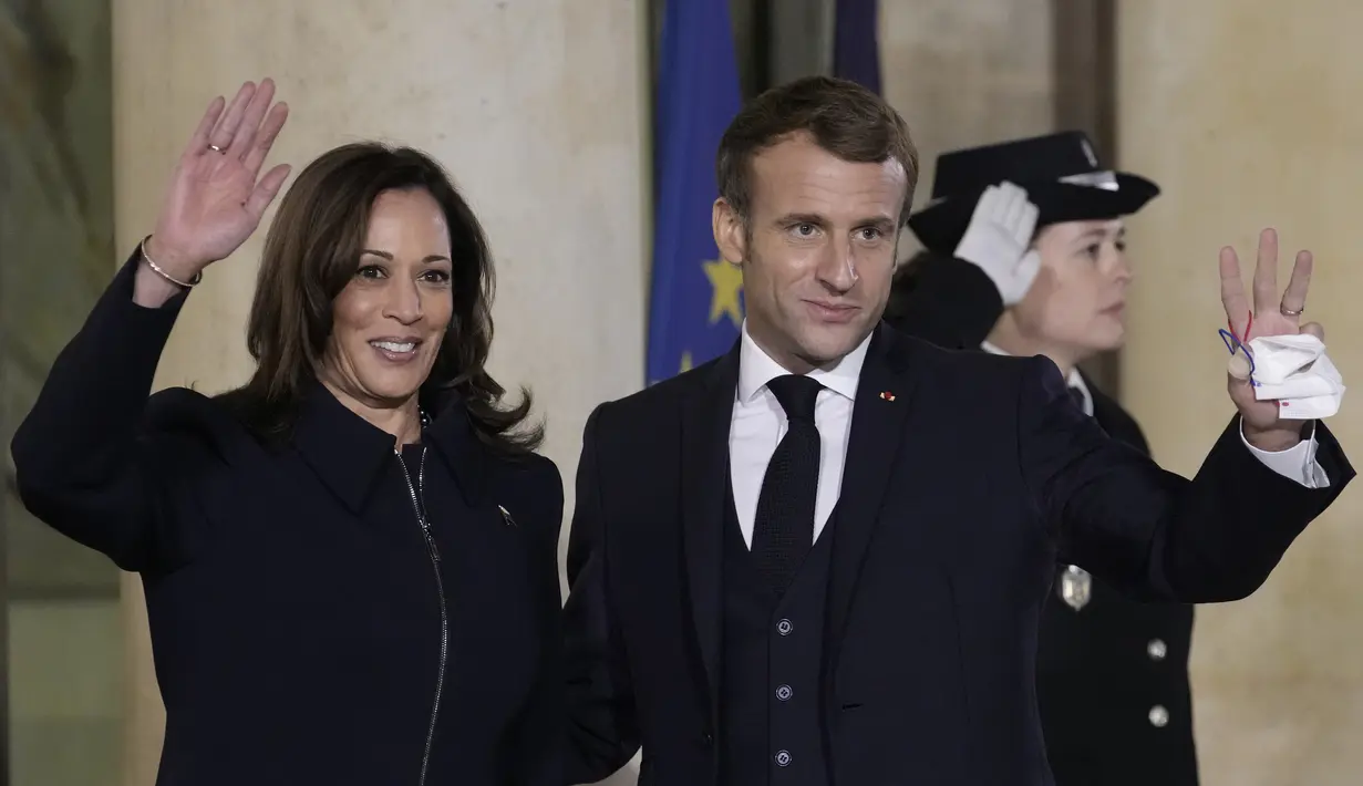 Presiden Prancis Emmanuel Macron dan Wakil Presiden AS, Kamala Harris melambaikan tangan menjelang pertemuan di Istana Elysee, Rabu (10/11/2021). Kamala Harris bertemu dengan Macron dalam upaya untuk meredakan ketegangan terkait kesepakatan kapal selam yang dibatalkan. (Ludovic MARIN/AFP)