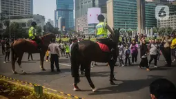 Sejumlah warga berfoto dengan polisi berkuda dari Direktorat Polisi Satwa Mabes Polri di kawasan Bundaran HI, Jakarta, Minggu (17/11/2019). Polisi berkuda tersebut khusus ditugaskan mengawasi keamanan CFD serta memperkenalkan kepada warga. (Liputan6.com/Faizal Fanani)