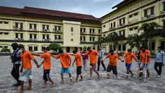 Tersangka penyelundup narkoba sekitar 81 kilogram sabu dan 20 kilogram ekstasi dikawal petugas saat riilis di Mapolda Aceh di Banda Aceh, Selasa (3/11/2020). (AFP/Chaideer Mahyuddin)