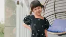 Berpose manis sambil menaruh satu tangannya di pinggang, Natusha terlihat mengenakan midi dress hitam dengan motif bunga-bunga yang kecil. Ia juga terlihat menguncir dua rambutnya. Foto: Instagram.
