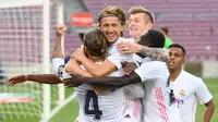 Pemain Real Madrid merayakan gol yang dicetak Luka Modric ke gawang Barcelona pada laga Liga Spanyol di Camp Nou Stadion, Sabtu (24/10/2020) malam WIB. Real Madrid menang 3-1 atas Barcelona. (AFP/Lluis Gene)