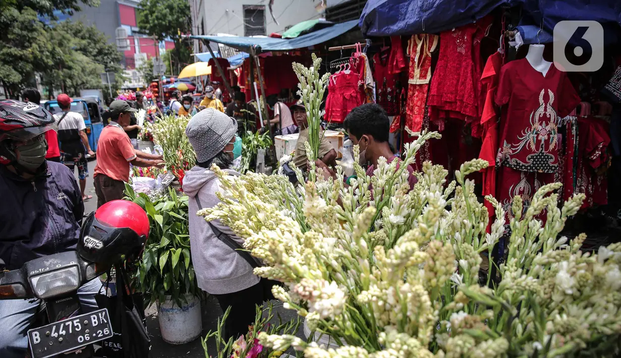 Penjual melayani pembeli bunga hias di Pasar Petak Sembilan, Glodok, Jakarta, Senin (31/1/2022). Jelang tahun baru Imlek 2573 sejumlah bunga seperti sedap malam, aster, mawar dan lainnya mulai banyak dicari warga Tionghoa untuk sembahyang. (Liputan6.com/Faizal Fanani)
